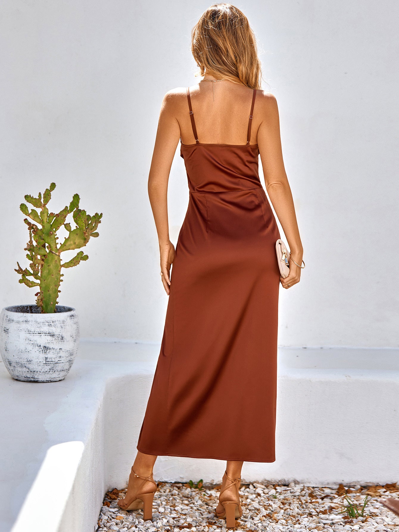 A dress featuring pleated detail, spaghetti straps, and a slit.