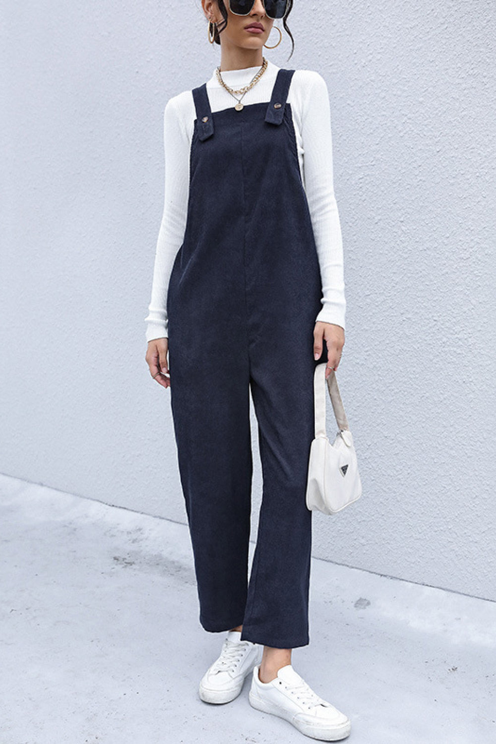 Stylish corduroy overalls with detailed button accents and convenient side pockets, perfect for a modern casual look.